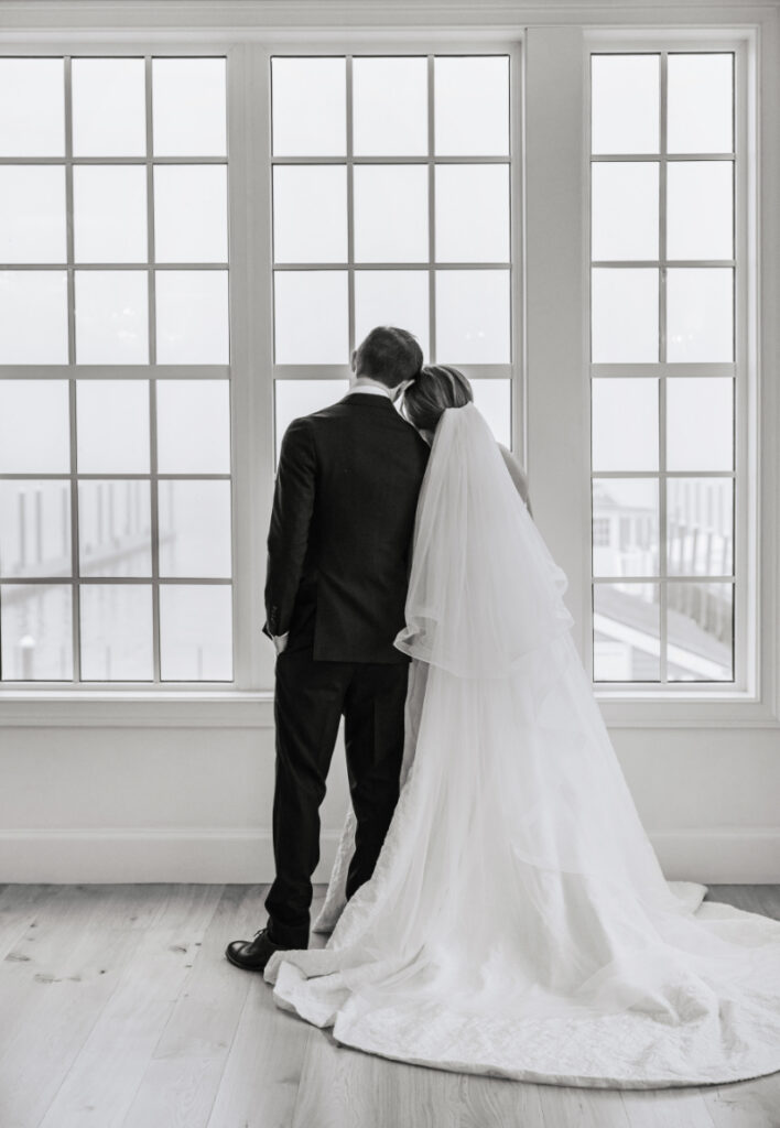 Black and white portrait of couple by windows, quiet moment together during Newport wedding