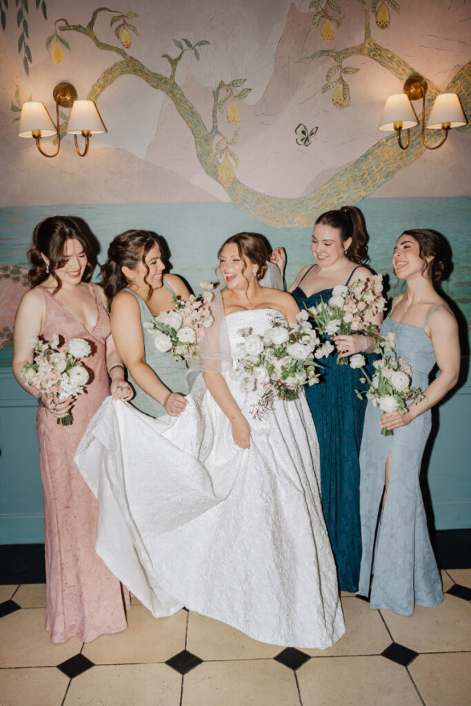 Bridal party laughing together with bouquets, playful and candid moment during Newport wedding