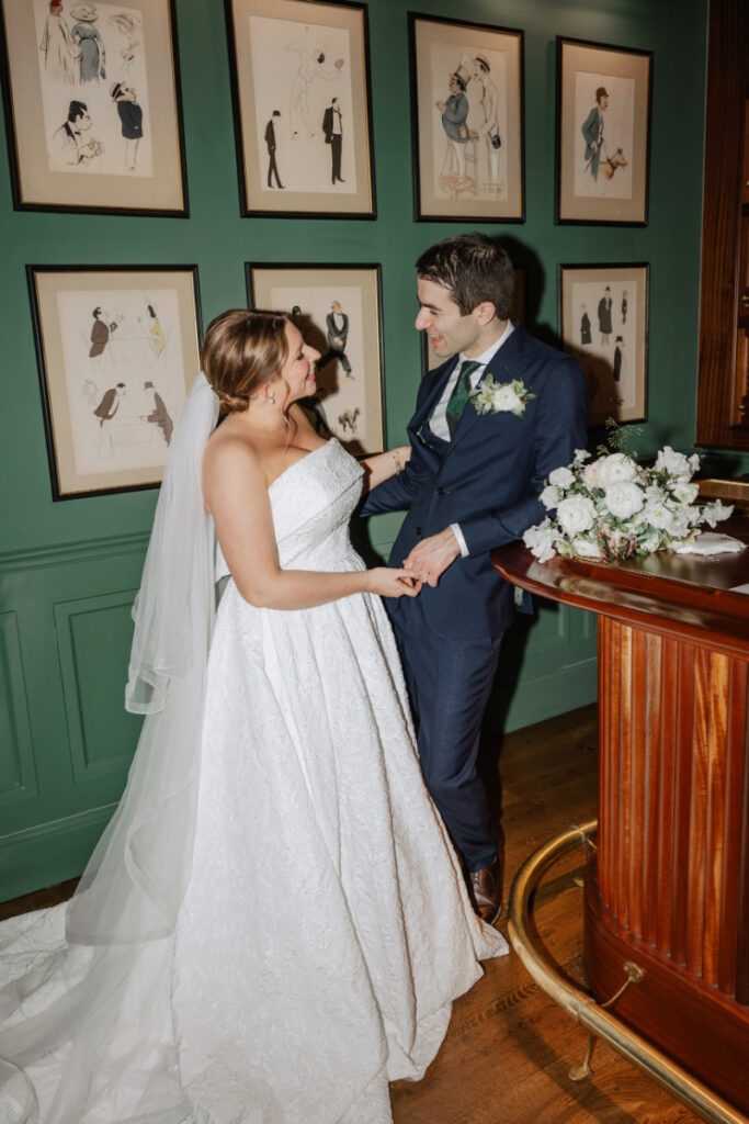 Bride and groom laughing together at bar with florals, intimate portrait during Newport wedding