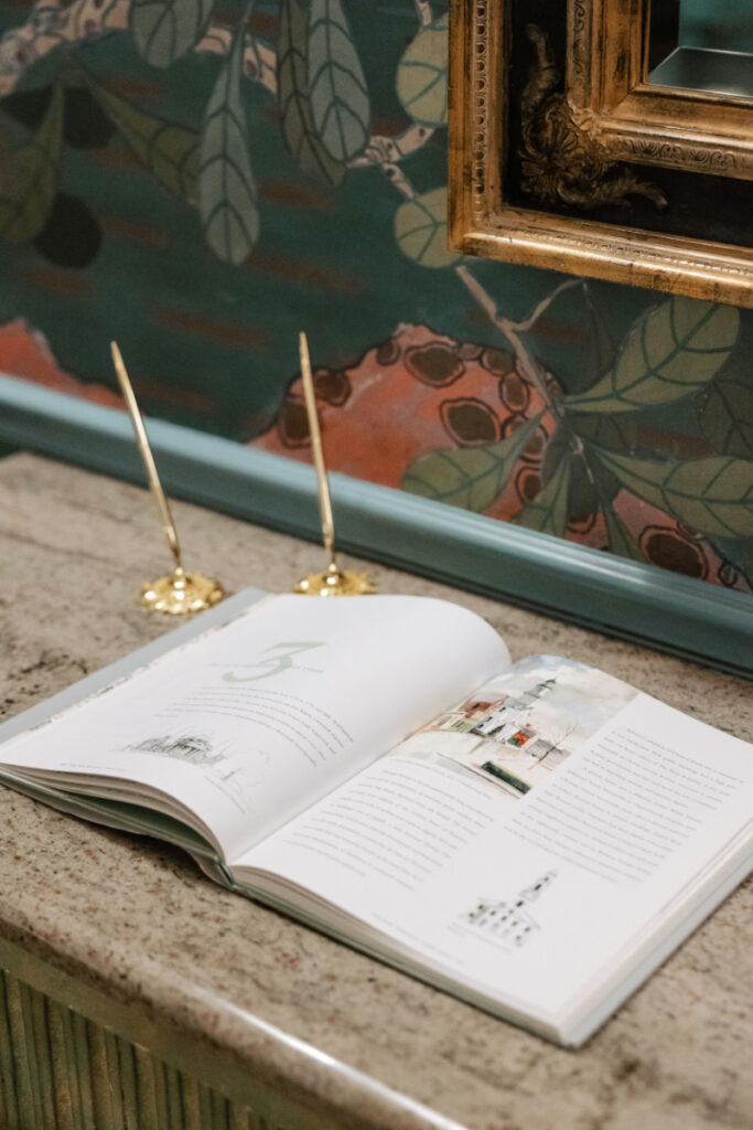 Guest book table with open album and gold pens, thoughtful detail captured at Newport wedding reception