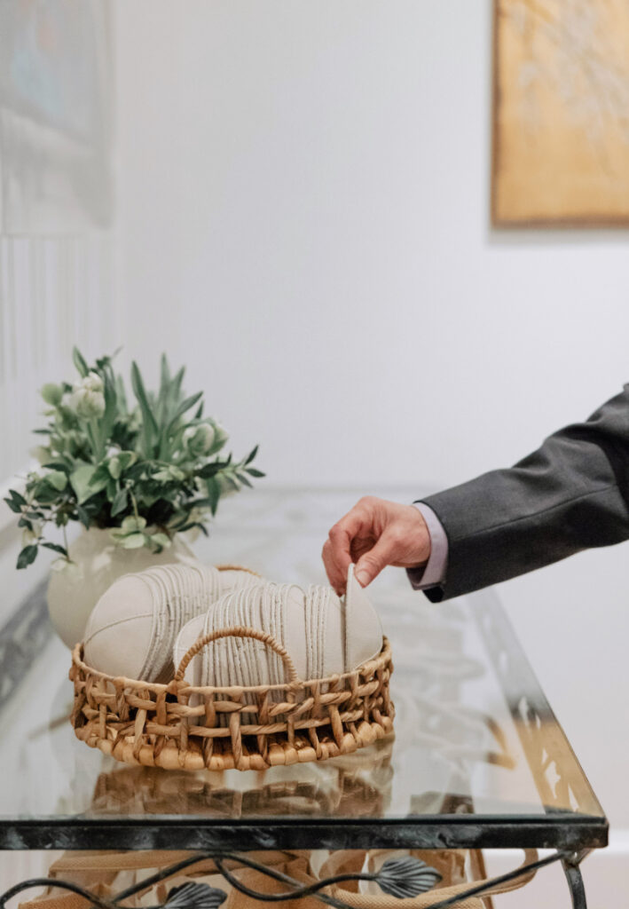 Guest selecting ceremony program from woven basket, thoughtful welcome detail at Newport wedding ceremony