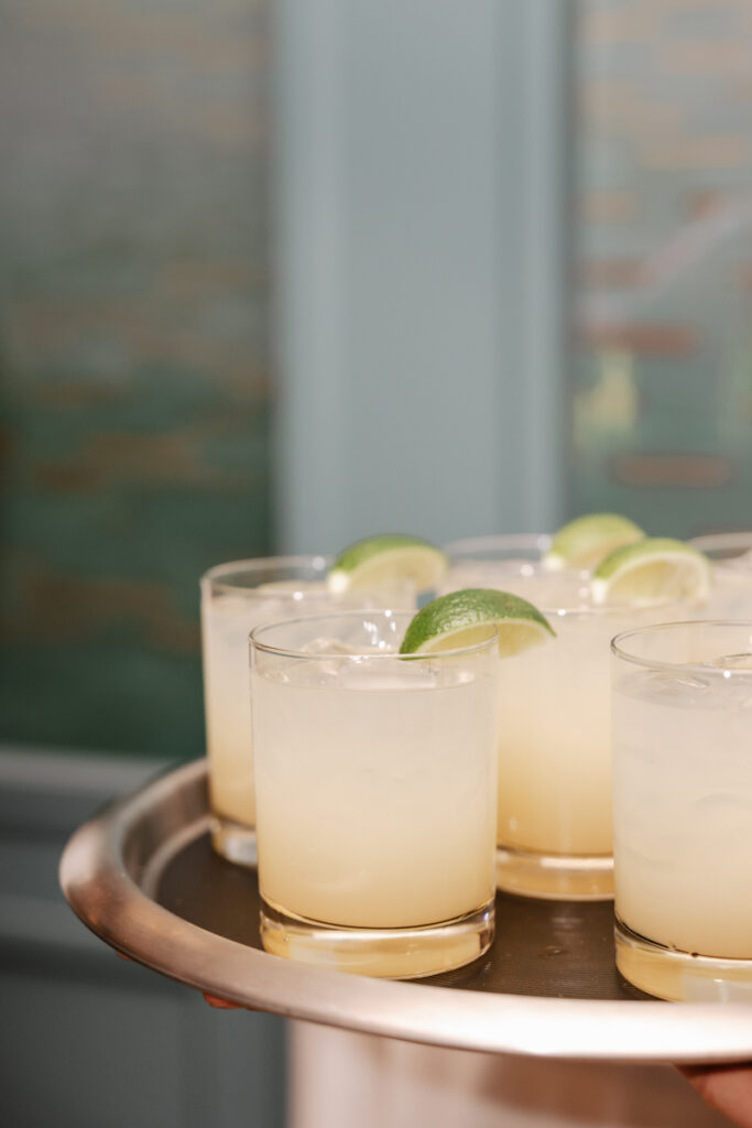 Signature cocktails with fresh lime garnish served on tray, a simple and elevated welcome detail for guests