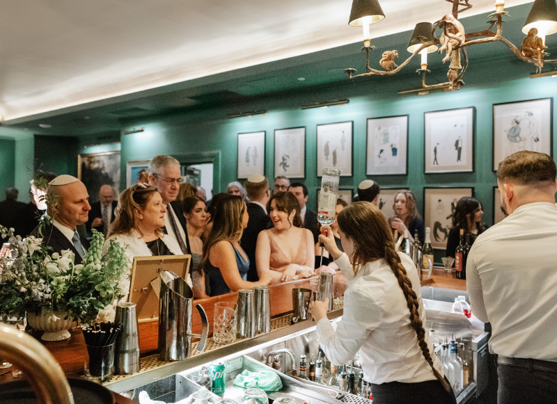 A packed bar in full swing (aka exactly what you want to see)—good drinks, great lighting, and guests fully in it, not checking their phones