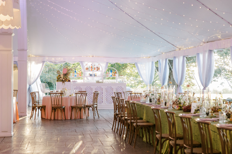 Wedding design ideas for a tented reception with soft lighting, layered tables, and a custom bar setup