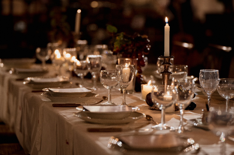 Candlelit reception table setup at Italian wedding destination with glassware, plates, and warm evening ambiance
